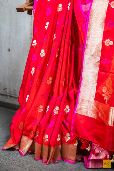 Designed with a stunning red and pink hue, this luxurious SAMANVITA saree is crafted from handwoven mashru banarasi silk and highlighted with intricate zari and pink buttas. Its supremely soft drape will feel exquisite against your skin and is complete with a shimmering brocade blouse. Exquisite and exclusive, this saree is the ultimate expression of luxury.  Fabric- Mashru silk  Colour- Red and pink
