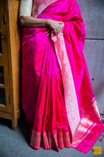 A PADMARAGA Banarasi Katan Silk Handwoven Saree is the pinnacle of luxury for those seeking a timeless and elegant look. This beautiful saree features intricate shikargah border and koniya that add a touch of sophistication to your wardrobe. Its soft texture and easy draping make it perfect for any special occasion. A shikargah blouse is adding to the beauty of this saree.  Fabric- Katan silk  Colour- Pink