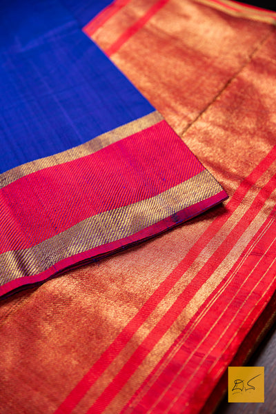 Close-up of a saree with blue, red, and gold colors.