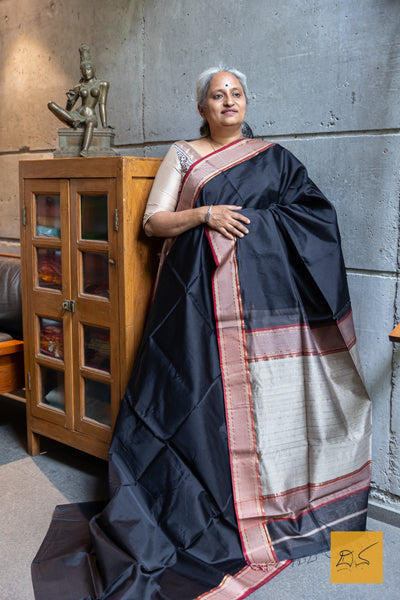 Experience the elegance of traditional Maheshwari silk and cotton with our BLACK-RED MAHESHWARI SILK COTTON HANDWOVEN SAREE. Perfect for casual or formal occasions, this saree comes with a matching blouse. Handwoven for a high-quality finish, it's a must-have addition to any wardrobe.