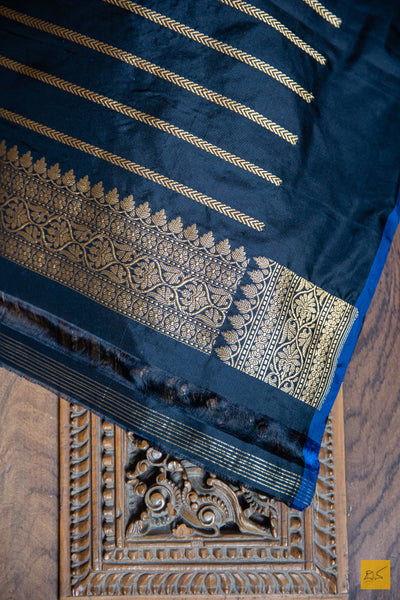 MUKTHAA Black Banarasi Katan Silk Saree is crafted with timeless elegance. Its soft material is easy to drape, while small buttas woven in cutwork style lend a charming look. Perfect for special occasions, this handwoven saree adds a classic touch to your wardrobe.