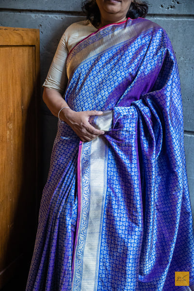 Experience the exquisite craft of luxury with our PRAHARSHITA Banarasi Katan Silk Handwoven Saree. Sumptuously handwoven from the finest blue katan silk, it seamlessly drapes the body with effortless grace. Delicate zari tanchoi adorns this beauty with a matching tanchoi silk blouse, captivating you with its undeniable sophistication.  Fabric- Katan silk