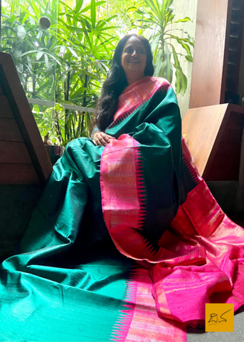 This exquisite Suvasini dupion silk saree, handwoven with a temple border, is perfect for special occasions. Crafted with intricate care, its charm and character will ensure you stand out from the crowd.  Fabric-Raw (Dupion) Silk.