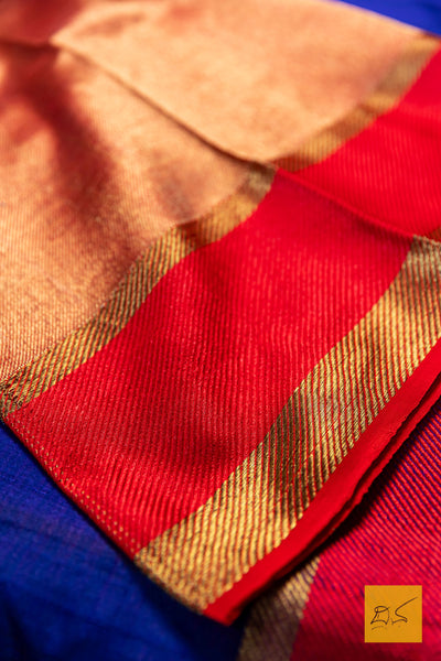 Close-up of a saree with red, gold, and blue colors.