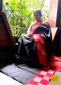 This Bhama dupion silk handwoven is a timeless combination of black and vibrant red. Its chequered border gives it a classic and sophisticated look perfect for special occasions and celebrations. Enjoy the feel of luxurious silk without compromising on style.