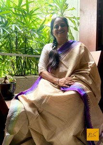 Vimala is a handwoven saree made from natural tussar silk. It features a purple combination with a temple border and a chequered zari pattern in the body. The tussar silk is known for its softness, lustre, and texture, making it a perfect choice for draping. Let this timeless piece add a touch of elegance to your wardrobe.