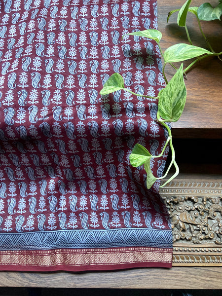 This traditional Maroon- Blue Bagh printed Maheshwari Saree is a classic combination of timeless elegance and modern fashion. Hand-printed in traditional bagh style in Madhya Pradesh and woven in Maheshwar, this saree is made from silk cotton and is easy to drape. It is a must-have for any wardrobe.