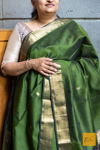 Indulge in the perfect blend of green and black with our Green-Black Maheshwari Silk Cotton Handwoven Saree. This elegant saree features small motifs in a soft and easy to drape fabric, perfect for any formal or informal occasion. Complete the look with the contrasting black blouse for a dressy and sophisticated ensemble.