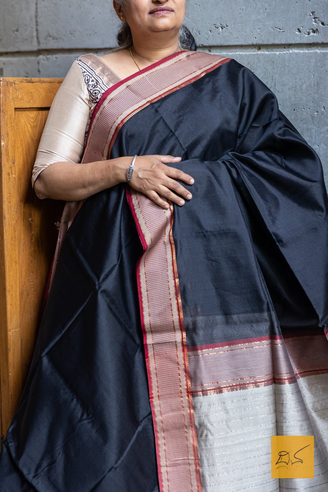 Experience the elegance of traditional Maheshwari silk and cotton with our BLACK-RED MAHESHWARI SILK COTTON HANDWOVEN SAREE. Perfect for casual or formal occasions, this saree comes with a matching blouse. Handwoven for a high-quality finish, it's a must-have addition to any wardrobe.