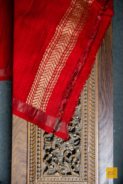 The exquisite Banarasi Matka Silk PRAFULLA saree instantly elevates your look—eliciting admiration from all who gaze upon its magnificence. Handwoven with intricate Kadhwa buttas, this luxurious ensemble is graced with a modern interplay of red and green hues, resulting in a garment of unparalleled elegance and finesse. Lightweight with an easy to drape design, this dressy saree is ideal for any special occasion.  Fabric-Raw(Dupion)Silk.