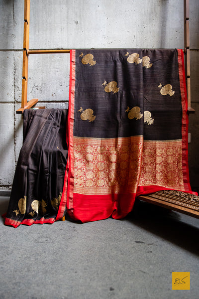 You are the MODEST!  Presenting this banarasi matka silk handwoven saree in dark brown and red. The saree has woven kadhwa buttas and the blouse is in red colour.