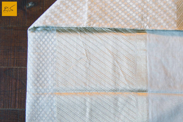 A lovely Banarasi cotton saree with buttas woven in cotton and zari. This is an example cutwork or katrua. The saree has a green selvedge which is enhancing the beauty. The blouse is of white colour with woven zari border. New trend of Banarasi Saree designs, Banarasi Saree for artists, art lovers, architects, saree lovers, Saree connoisseurs, musicians, dancers, doctors, Banarasi Katan silk saree, indian saree images, latest sarees with price, only saree images, new Banarasi saree design.