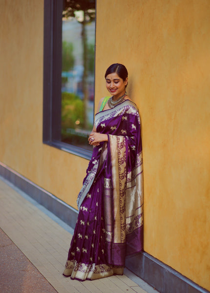 Put yourself first. Make yourself a priority and treat yourself with this truly royal and timeless purple banarasi katan silk  handwoven saree with kadhwa butttas. The saree has all over sona rupa lion motifs and pinkish red selvedge.