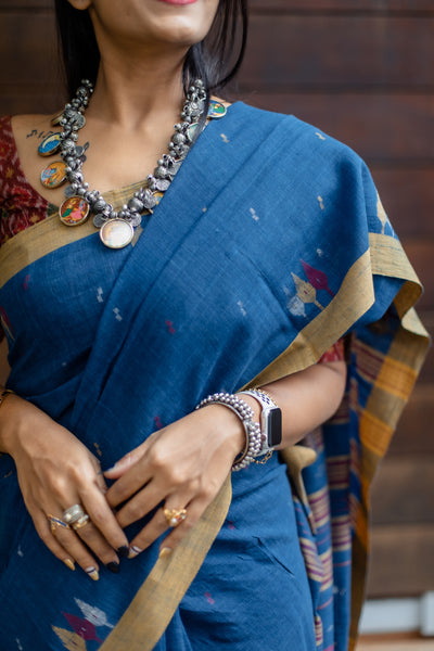 This Sukeerthi Hand spun Cotton Handwoven Jamdani Saree is perfect for a comfortable and stylish look. Crafted with hand-spun cotton and a classic Jamdani weave, this saree features an indigo shade and smooth handwoven finish for a rich, luxurious look. Enjoy a timeless style with modern comfort.