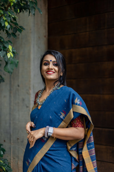This Sukeerthi Hand spun Cotton Handwoven Jamdani Saree is perfect for a comfortable and stylish look. Crafted with hand-spun cotton and a classic Jamdani weave, this saree features an indigo shade and smooth handwoven finish for a rich, luxurious look. Enjoy a timeless style with modern comfort.